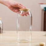 ⁦برطمان بيضاوي لتر زجاج غطاء خشب محكم الغلق لحفظ وتنظيم البقوليات والمكسرات والكورن فليكس والمارشميلو ‏⁩ - الصورة ⁦2⁩