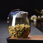 ⁦برطمان زجاج شفاف 700 ملي لحفظ البقوليات والمكسرات والكاندي بغطاء محكم الغلق مزين بقماش منقوش ورد⁩ - الصورة ⁦8⁩