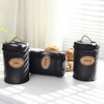 ⁦طقم برطمانات 3 قطع 500 ملي لحفظ وتنظيم الشاي والسكر والقهوة معدن بغطاء محكم الغلق بيد جلد⁩ - الصورة ⁦3⁩