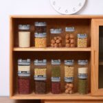 ⁦طقم علب 4 قطع بمقاسات مختلفة لحفظ وتنظيم البقوليات والحبوب والكاندي بغطاء محكم الغلق بيد من الاكليريك⁩ - الصورة ⁦6⁩