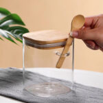 ⁦برطمان زجاج لحفظ وتنظيم البقوليات والمكسرات والكورن فليكس 800 ملي بغطاء خشبي ومعلقة لسهولة الأستخدام⁩ - الصورة ⁦2⁩