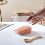 ⁦برطمان زجاج لحفظ وتنظيم البقوليات والمكسرات والكورن فليكس 800 ملي بغطاء خشبي ومعلقة لسهولة الأستخدام⁩ - الصورة ⁦7⁩