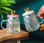 مج زجاج متعرج 450 ملي بغطاء تاج ومعلقة استانليس ستيل جولد للمشروبات الباردة والساخنة بيد