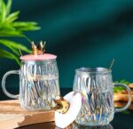 ⁦مج زجاج متعرج 450 ملي بغطاء تاج ومعلقة استانليس ستيل جولد للمشروبات الباردة والساخنة بيد⁩ - الصورة ⁦6⁩