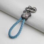 ⁦ميدالية جلد مضفر برأس دبدوب لمفاتيح السيارات والشنط مع جزء مخصص لكتابة رقم الموبايل⁩ - الصورة ⁦8⁩