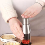 مفرمة يدوية بمكبس لهرس الثوم والخضروات مزودة بشفرات ستاليس من الداخل